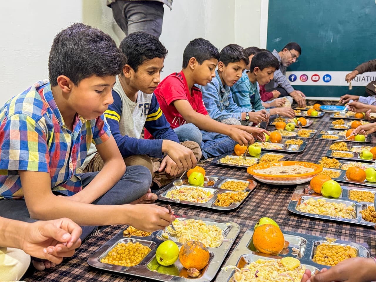 Children eating together during daily mealtime at Baqiatullah Foundation orphanage